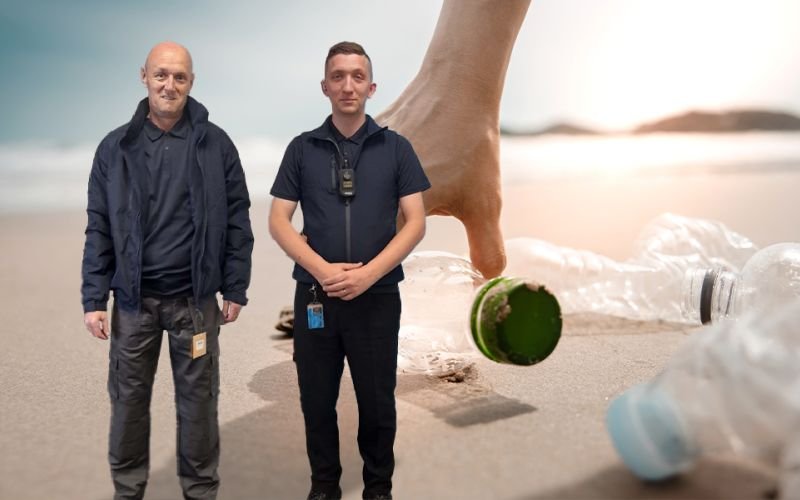 Hand picking a bottle off a beach as a backdrop with two ABM employees wearing sustainable workwear in the foreground