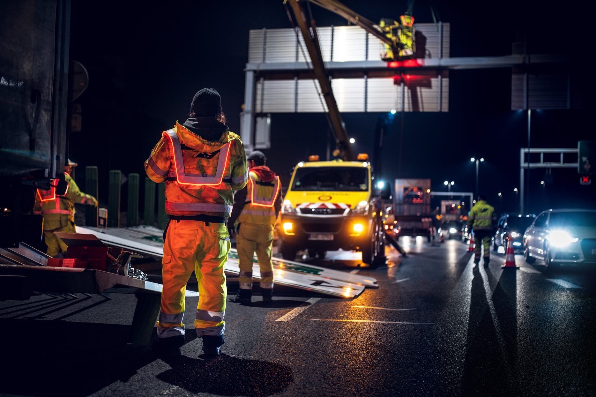 Night traffic scene with workmen wearing LED Safety Vest