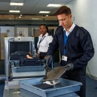 Male and female security officers working in security area