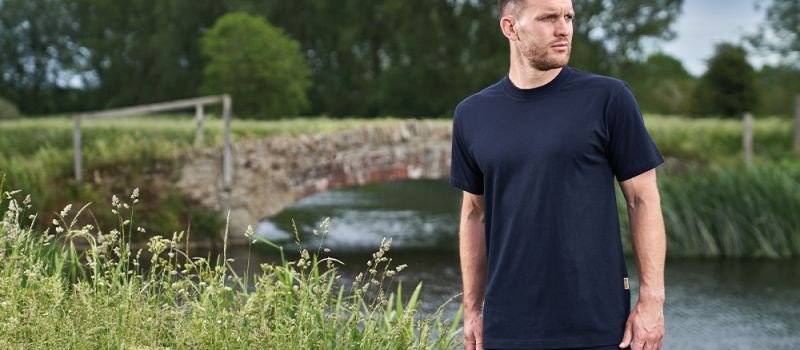 Man in smart black T shirt and cargo trousers by a stream