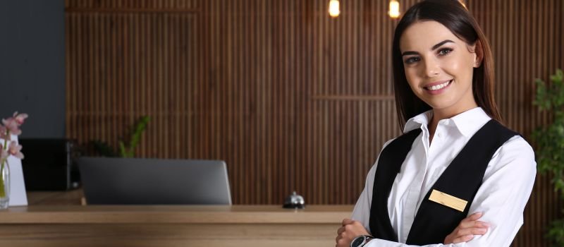 Receptionist in white shirt and black waistcoat