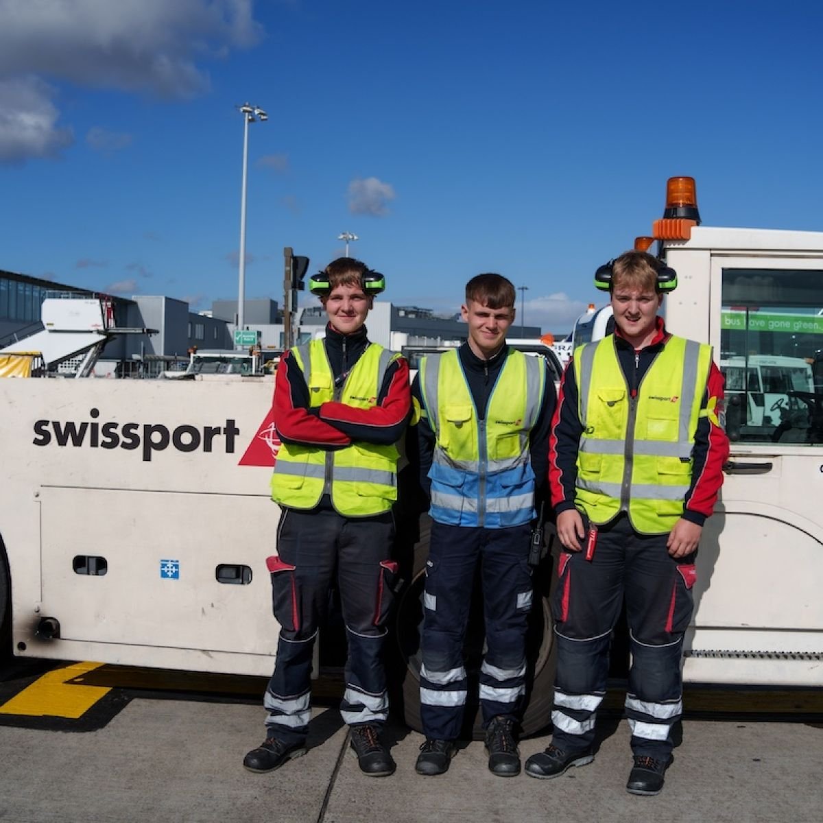 3 Swissport Ramp Agents next to a tow truck