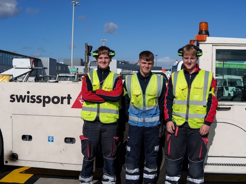 3 Swissport Ramp Agents next to a tow truck