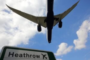 Plan flying over Heathrow sign